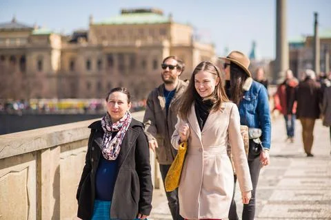 The Charles Bridge is crowded of people, while tourists enjoy walking interac Stock Photos