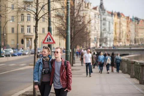 The Charles Bridge is crowded of people, while tourists enjoy walking interac Stock Photos