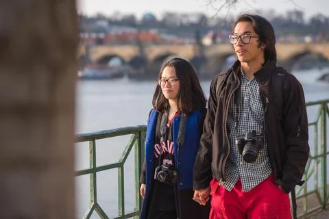 The Charles Bridge is crowded of people, while tourists enjoy walking interac Stock Photos