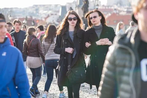 The Charles Bridge is crowded of people, while tourists enjoy walking interac Stock Photos