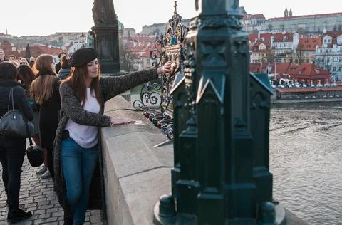 The Charles Bridge is crowded of people, while tourists enjoy walking interac Stock Photos