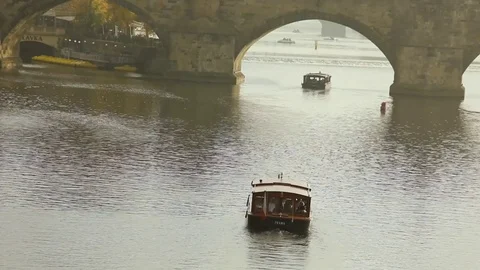 Charles bridge, Prague against the backdrop of a tourist ship at sunset Stock Footage 83662957