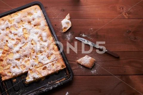 Charlotte apple cake in the pan and slices of cake Stock Photos