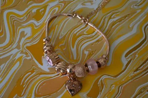 Charm bracelet on patterned background Stock Photos