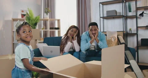 Charming 4-aged black-skinned girl pulling empty carton box when her tired Stock Footage 150691353