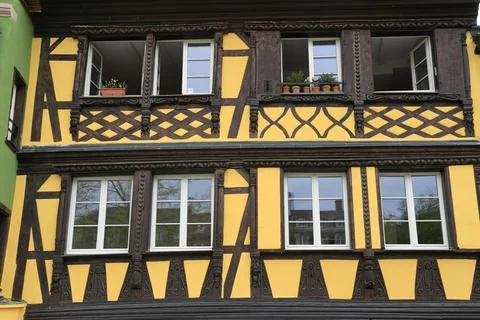 Charming Alsace half-timbered house with vibrant yellow shutters Stock Photos