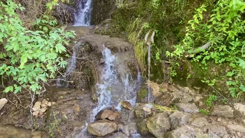 Charming and beautiful waterfall flows out from the top of the mountain Stock Footage 249932032