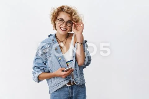 Charming and charismatic young stylish blond girl in glasses and makeup holding Stock Photos