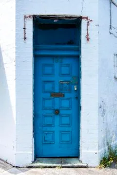 Charming and Rustic Blue Door in Old White Painted Brick Building Stock Photos
