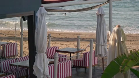 Charming Beachside Cafe with Striped Chairs and Umbrellas Video stock 307173600