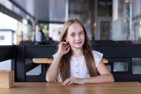 Charming blond model sitting alone at street cafe Stock Photos