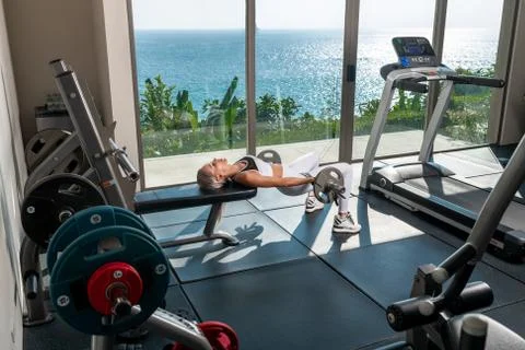 Charming blonde doing workout in front of the window Stock Photos