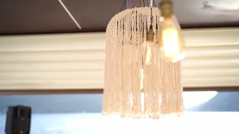 Charming boho fringe lamp adds inviting glow to seaside interior scenes Stock Footage 343119449