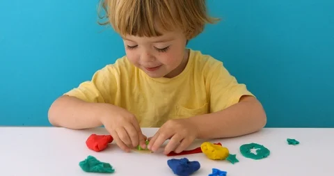 Charming boy with play dough at table Stock Footage 111758199