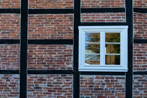 Charming brick and timber frame wall with a white window detail Stock Photos