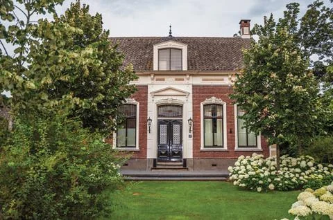 Charming brick rustic house with flowered garden in Drimmelen Stock Photos