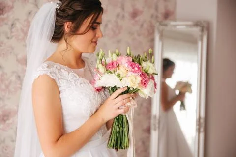 Charming bride stand in front of window. Girl stand by the window at her room Stockfoto's