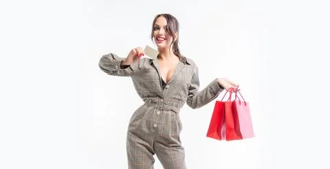 Charming brunette posing in the studio with red packages and a bank card. G.. Stock Photos