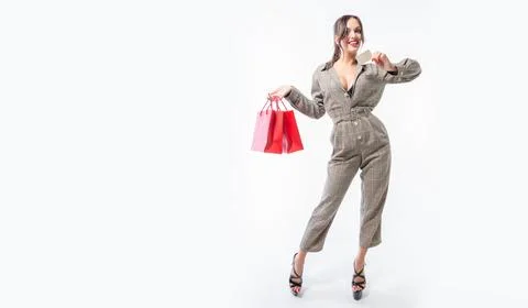Charming brunette posing in the studio with red packages and a bank card. G.. Stock Photos