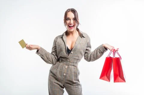 Charming brunette posing in the studio with red packages and a bank card. G.. Stock Photos