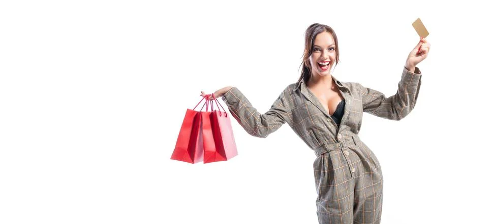 Charming brunette posing in the studio with red packages and a bank card. G.. Foto stock