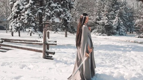 Charming brunette stands alone at the exit from her village, lowers her sword in Video stock 102621459