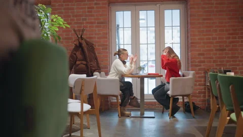 Charming cafe scene. Friends share laughter and stories inside cozy urban cafe Stock-Footage 345177319