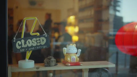 Charming cafe showcases closed sign and lucky cat decoration shot from the Stock Footage 296012734
