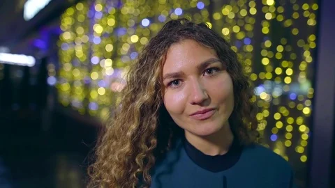 Charming caucasian girl is looking at camera, standing in background of holidays 库存影片 97414341