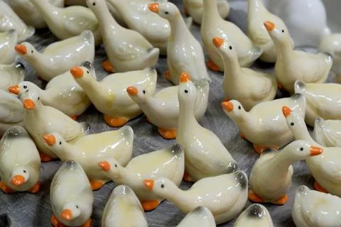 Charming ceramic ducks gathered at a vibrant market stall Stock Photos