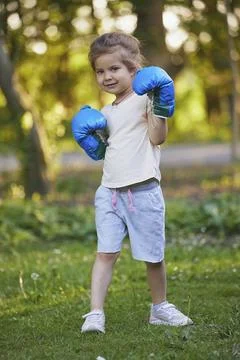 Charming child doing boxing in the backyard on the Sunset Stock Photos