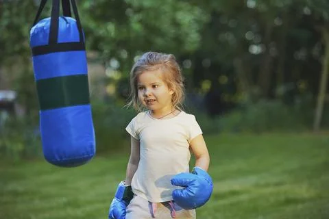Charming child doing boxing in the backyard on the Sunset Stock Photos