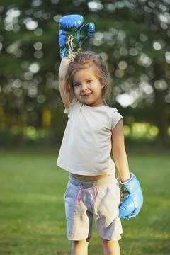 Charming child doing boxing in the backyard on the Sunset Stock Photos
