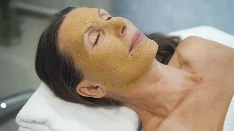 Charming client lying in spa salon with peeling mask on face Stock Footage 114003676