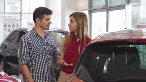 Charming couple exploring a sleek new automobile at the dealership Video stock 311182094