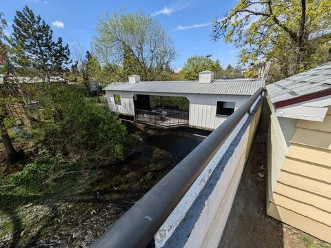 Charming covered bridge spanning a flowing river, featuring open viewing areas Фото