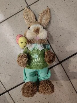 Charming Easter bunny decoration holding colorful eggs, crafted from natura.. Stock Photos