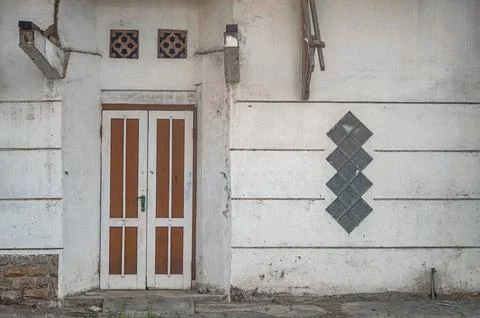 Charming facade of an old building featuring a rustic wooden door, unique d.. Stock Photos