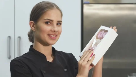 Charming female baker joyfully presenting a box of delightful marshmallows Stock Footage 311545662