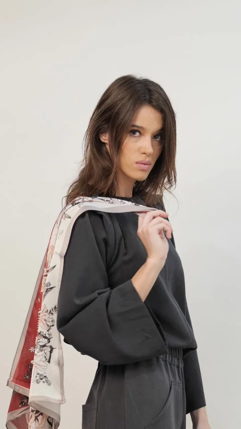 Charming female holding leaf pattern cloth in white studio Stock Footage 259865505