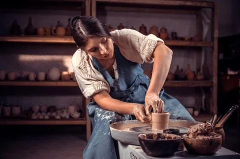 Charming female master demonstrates the process of making ceramic dishes using Stock Photos