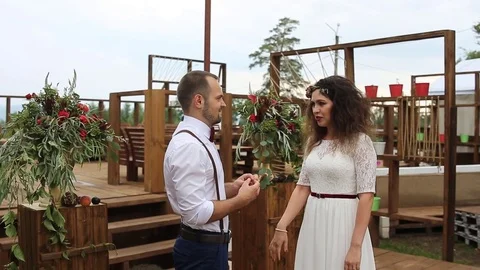 Charming, the groom wears wedding ring on the finger of his bride. Stock Footage 69889051