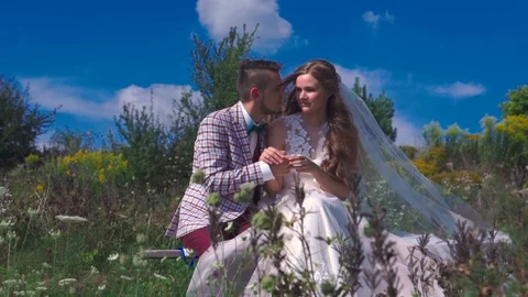 Charming happy couple of newlyweds sitting on a bench on the nature scenic Stock Footage 97657553