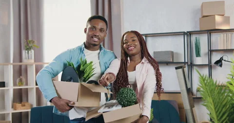 Charming happy smiling young modern african american couple holding carton boxes Stock Footage 150701759