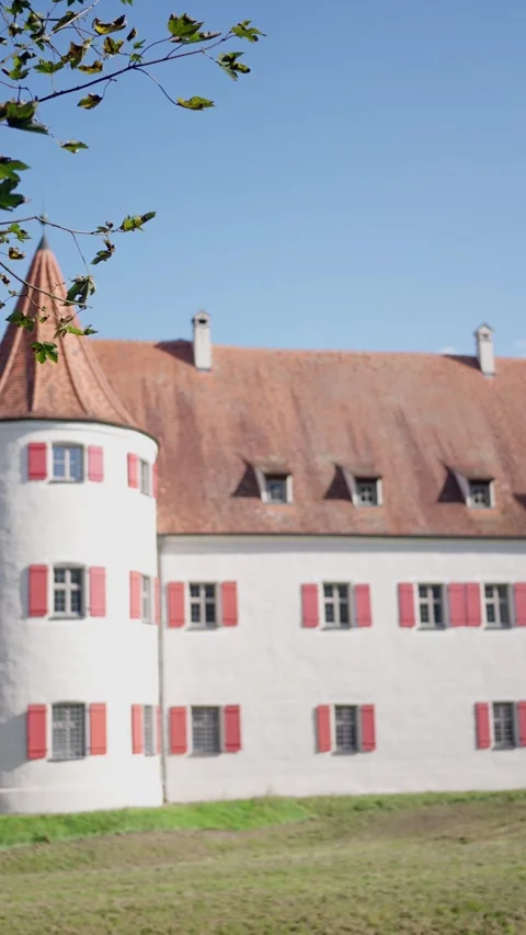 A Charming Historic Castle with Inviting Red Shutters Nestled Under a Clear Blue Stock-Footage 318717101