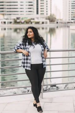 A charming Indian woman laughs while walking around the city. The concept of Stock Photos