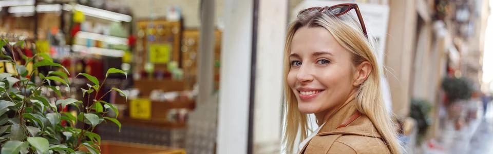 Charming lady looking at camera while touching plant leaf Stock Photos