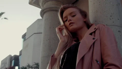 Charming lady looks at the camera on wall grey city background Stock Footage 151226461