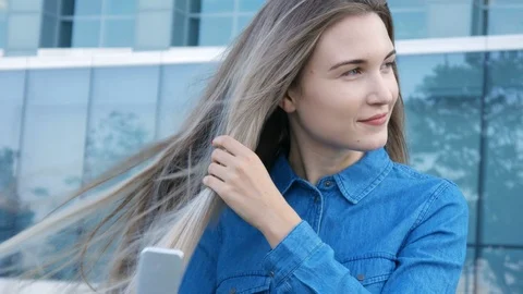 Charming lady trying to comb brush her hair in a heavy wind 库存影片 101238220