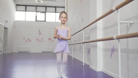 Charming little ballerina gracefully practicing her dance moves at ballet school Stock Footage 311943361
